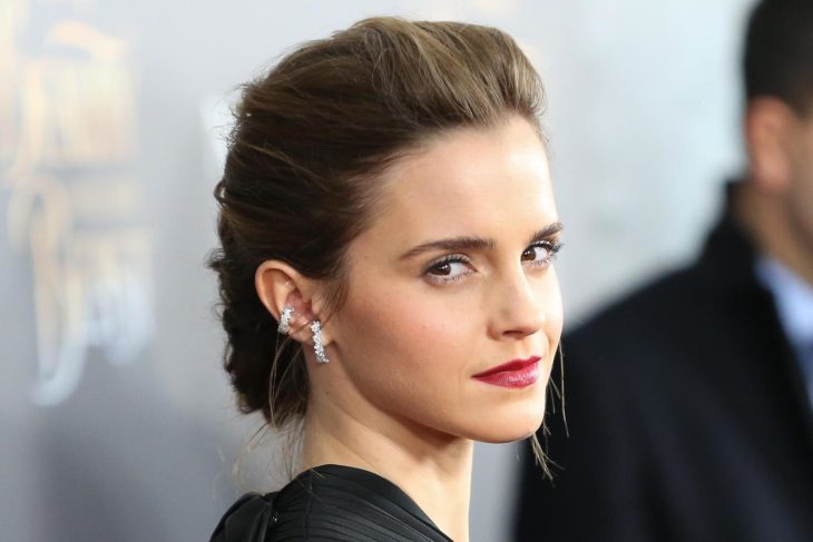 Emma Watson posando de perfil para una fotografía durante una alfombra roja