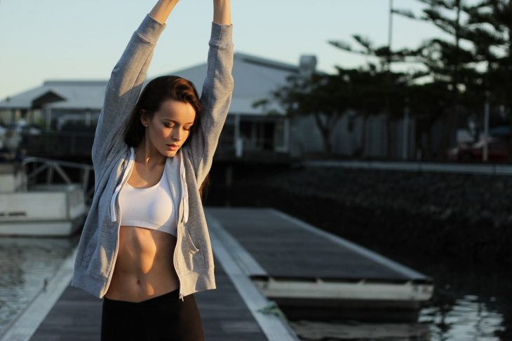 Mujer con ropa deportiva haciendo estiramientos