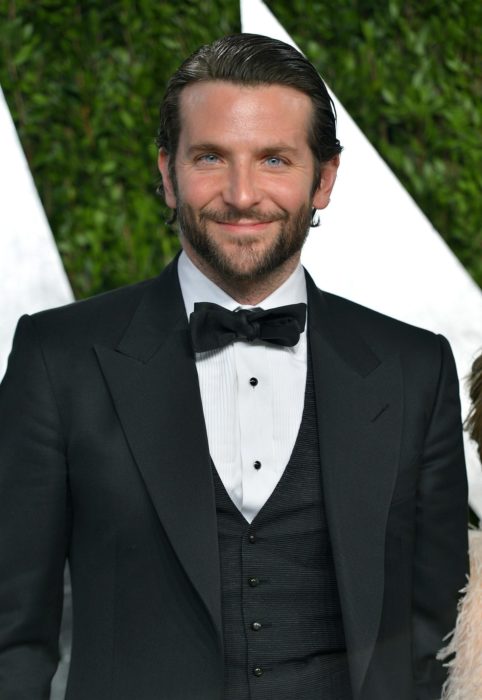 Actor, director y cantante Bradley Cooper con traje negro y moño, con barba y peinado hacia atrás