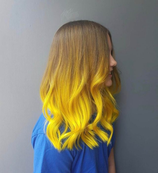 Chica de perfil con cabello largo abajo de los hombros de color castaño degradado a amarillo