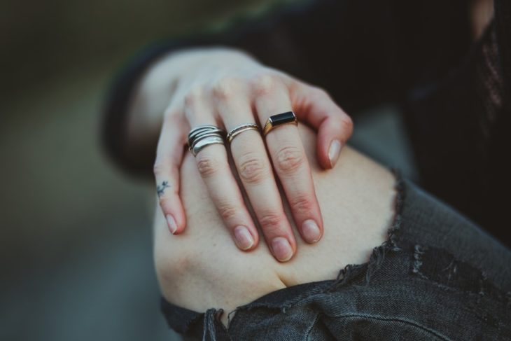 mano de mujer con anillos sobre rodilla