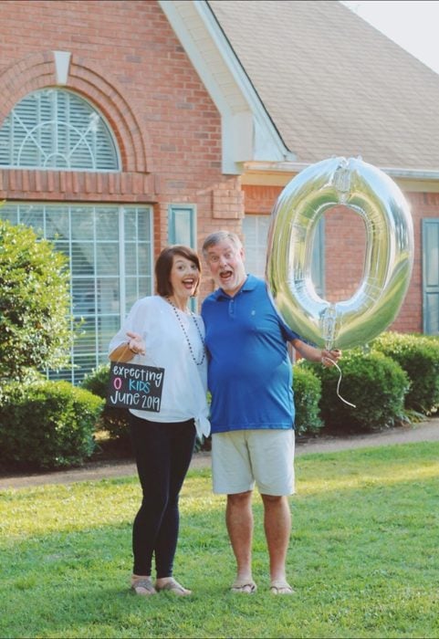 Amy y Randy English a mitad del jardín sosteniendo un globo de helio 