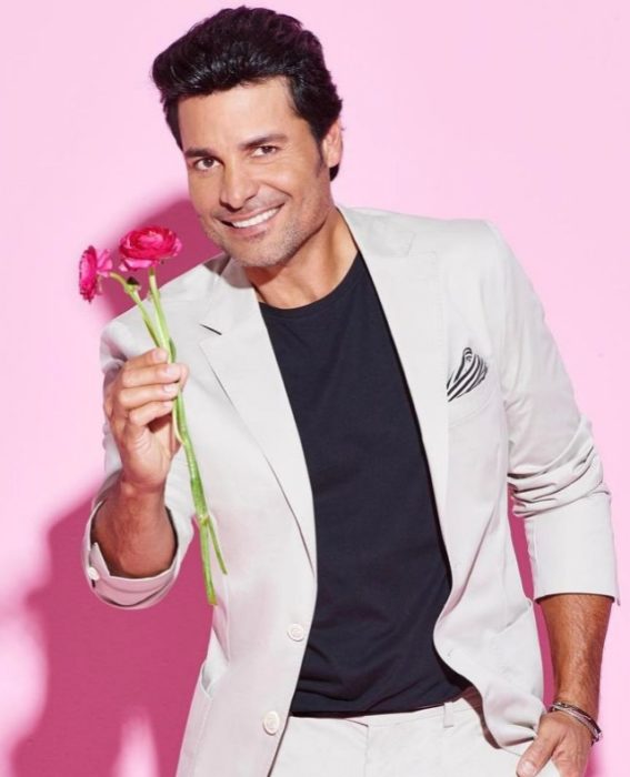 ChAyanne durante una sesión de fotos, sosteniendo flores colo rosa fucsia 