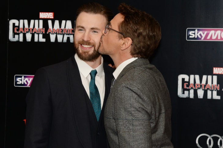 Robert Downey Jr. le da un beso en la mejilla a Chris Evans durante una alfombra roja