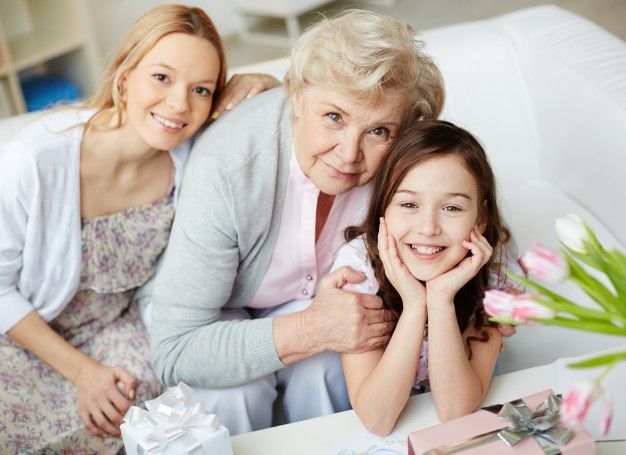 una mamá, abuela y nieta en una sala blanca