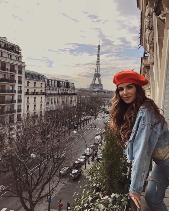 Cosas que debes hacer en vez de enamorarte; chica de cabello castaño con boina roja en un balcón frente a la torre Eiffel