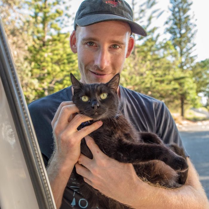 Rich sosteniendo al gato negro, Willow entre su sbrazos