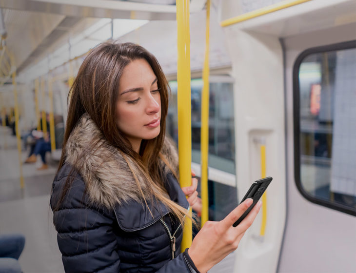 Mujer en el metro viendo su teléfono celular