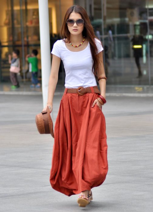 Faldas para el verano; chica caminando en la calle con falda roja, larga y con bolsillos