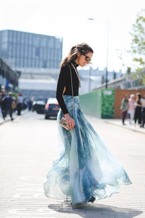 Faldas para el verano; chica con blusa negra de mangas largas y falda de gasa color azul cielo