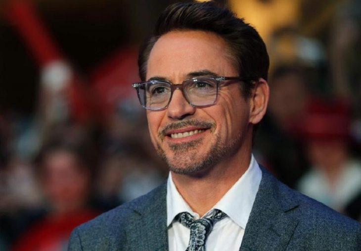 Actor de Iron Man, Robert Downey Jr. con traje gris y lentes de aumento