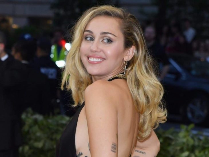 Actriz y cantante Miley Cyrus con cabello rubio, suelto y ondulado