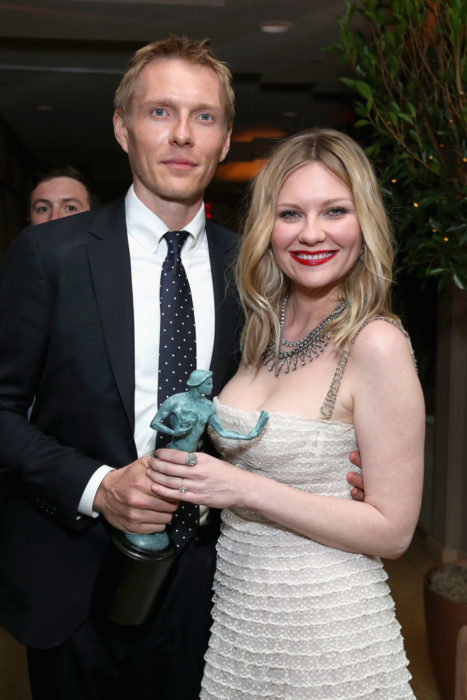 Christian Y Kirsten Dunst sosteniendo un premio