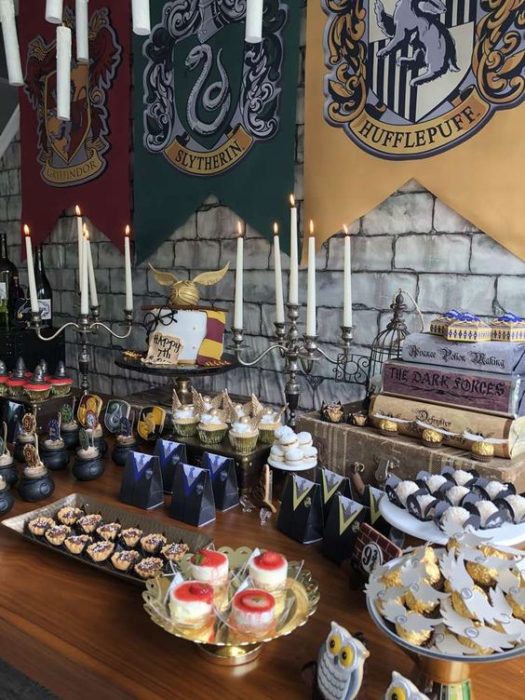 Mesa de dulces con las banderas de las casas mágicas de Harry Potter