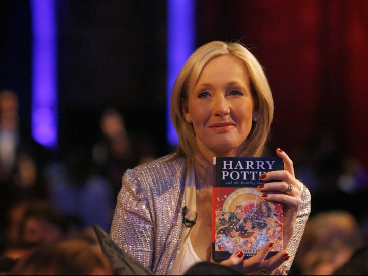 Escritora y autora de los libros de Harry Potter, J.K. Rowling sosteniendo un libro de la saga