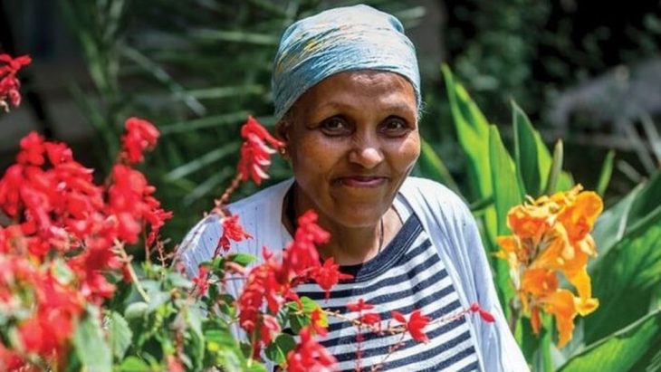 Mamitu Gashe en un jardín entre flores