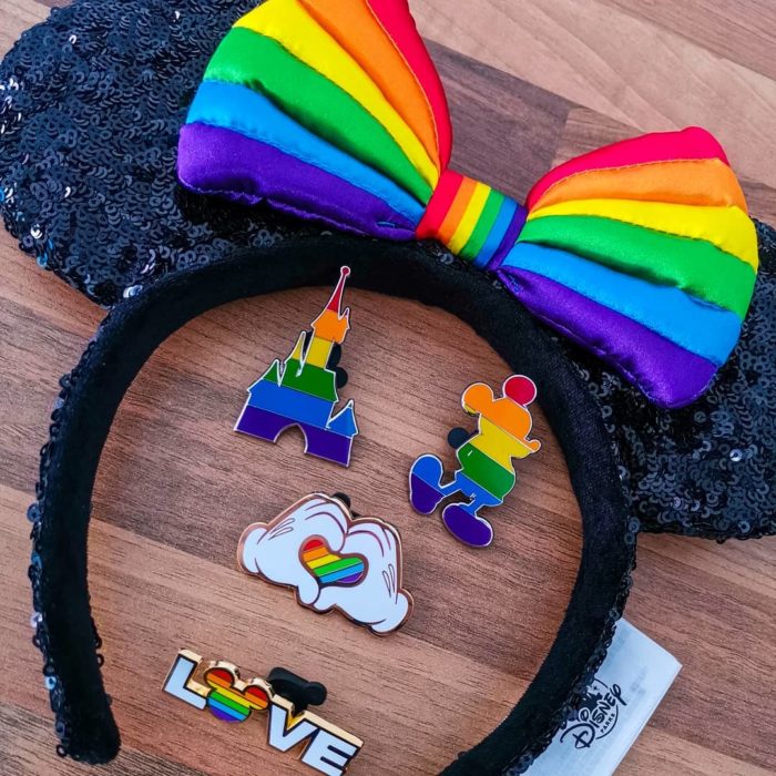 Magical Pride en Disneylandia; recuerdos de Disney con bandera de colores; diadema con orejas de Minnie Mouse y pines de Mickey y castillo