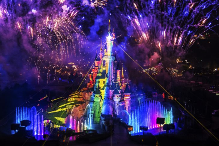 Magical Pride en Disneylandia; castillo de parque de diversiones iluminado con colores