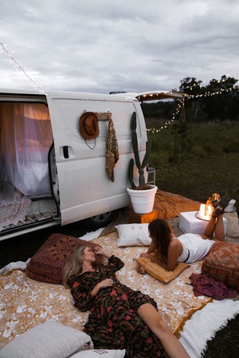 Mujeres en un campamento improvisado con una furgoneta al aire libre