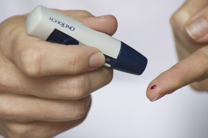 manos de una persona que se está haciendo una prueba de diabetes con el onetouch