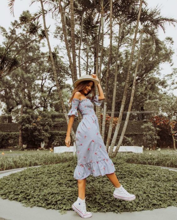 Chica con vestido estilo campesino, posando en un jardín o parque