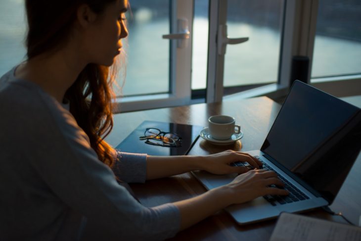 mujer sentada en escritorio frente a laptop