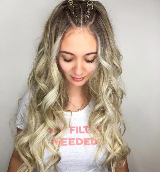 Peinados para el calor; chica de cabello rubio, largo y ondulado, con dos trenzas adornadas con anillos en la parte de arriba