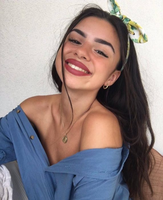 Peinados para el calor; chica sonriendo, con cabello largo y castaño peinado con una bandana