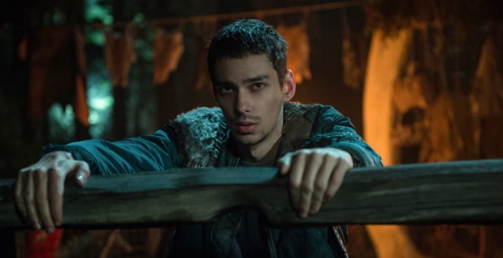 Jasper Jordan detrás de una cerca de madera, escena de la serie The 100