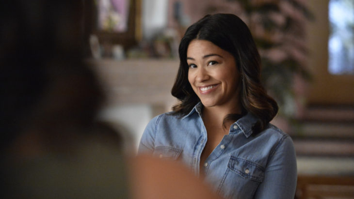 Jane Villanueva sonriendo y charlo con una persona, escena de la serie Jane the Virgin