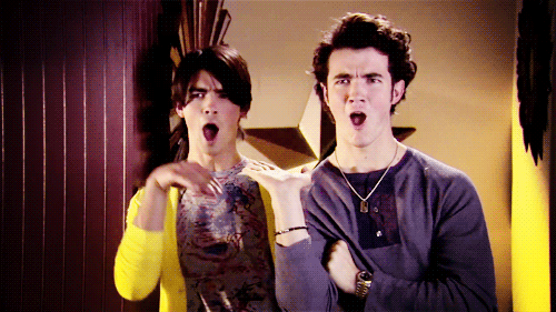 Gif Jonas Brothers reaccionando emocionados y chocando sus palmas