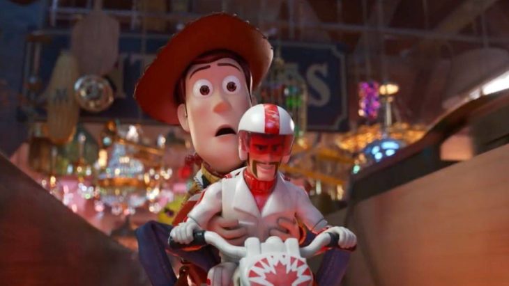 Escena de la película Toy Story 4. Woody sujetando a Duke Caboom mientras van en una motocicleta 