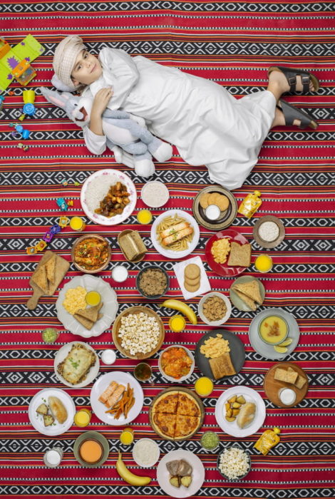 Niña recostada en una alfombra a rayas, proyecto fotográfico de Gregg Segal