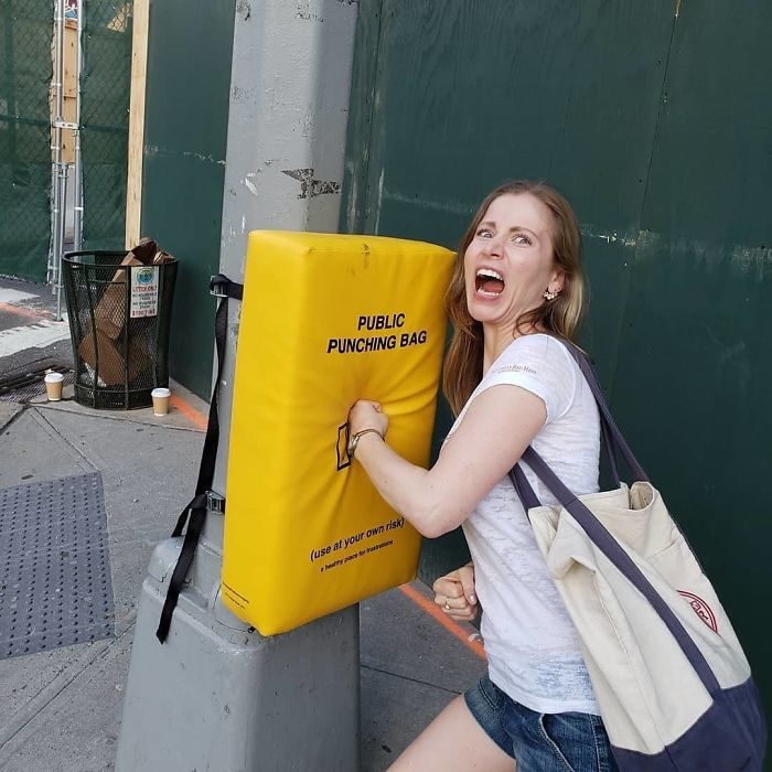 Chica golpeando un saco de box instalado en un poste