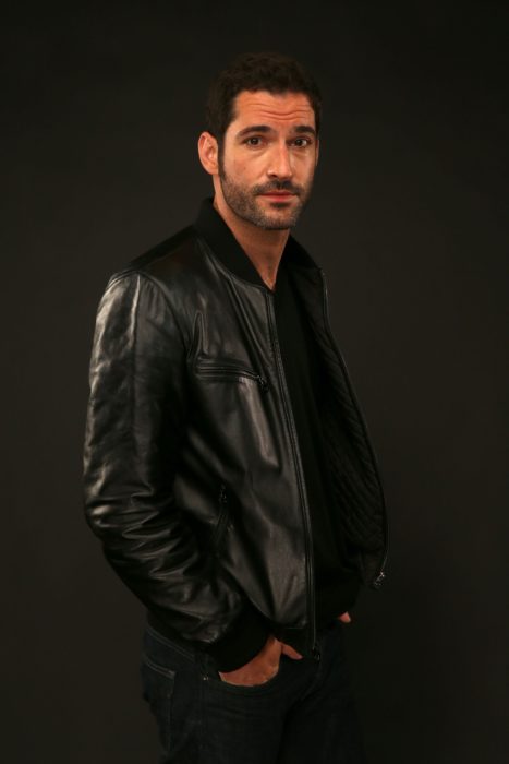 Actor de serie de Netflix, Lucifer, Tom Ellis; hombre con chamarra de cuero y manos en los bolsillos del pantalón 