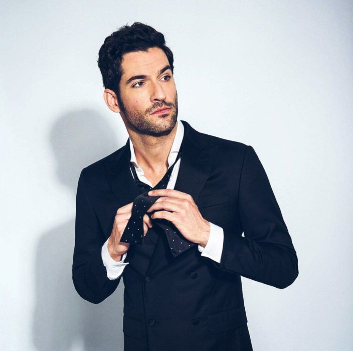 Actor de serie de Netflix, Lucifer, Tom Ellis; hombre de rtaje acomodándose la corbata