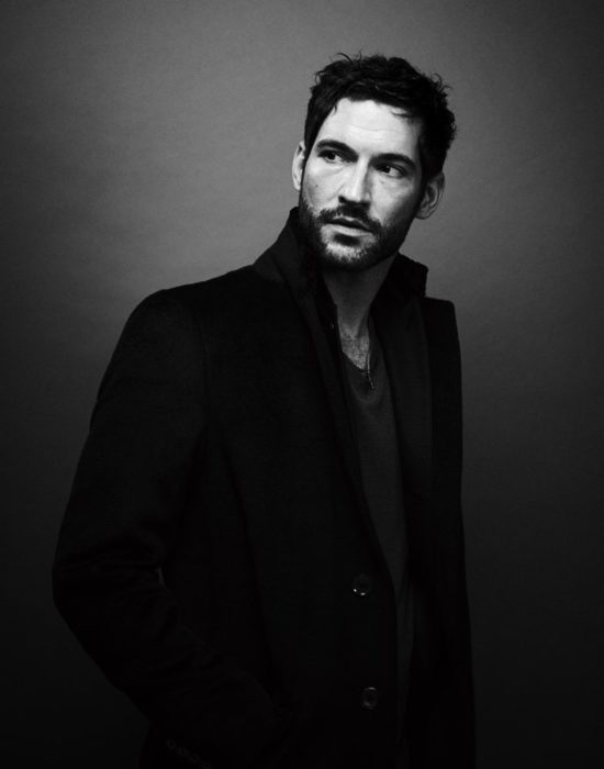 Actor de serie de Netflix, Lucifer, Tom Ellis; fotografía en blanco y negro de hombre con barba y gabardina negra