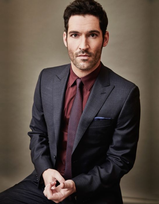 Actor de serie de Netflix, Lucifer, Tom Ellis; hombre con traje gris, camisa guinda y corbata