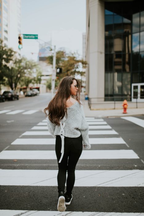 Chica caminando a punto de cruzar una avenida