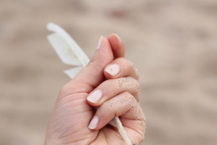 Manos de mujer sosteniendo una pluma