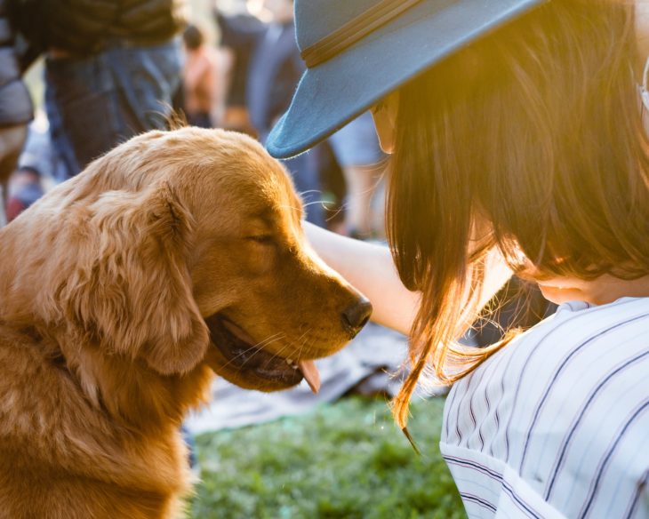 mujer con perro dorado