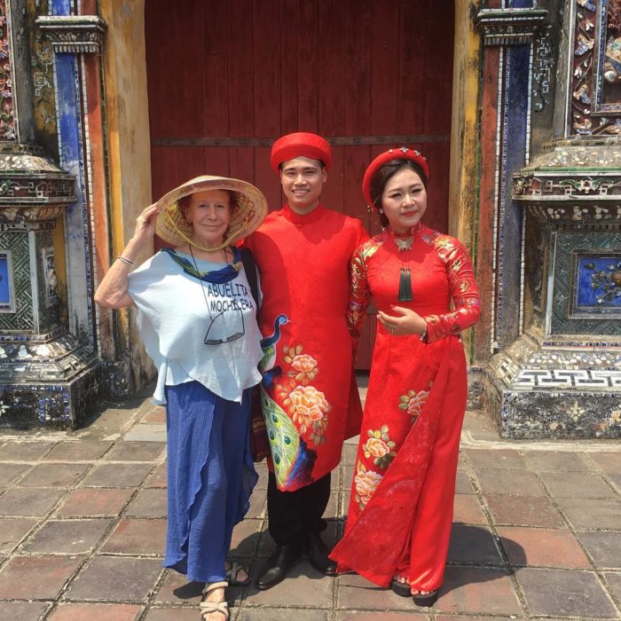 Abuelita mochilera que viaja alrededor del mundo posando con dos personas de China