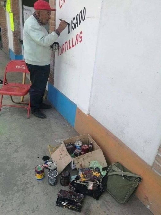 Señor de 79 años pintando la pared de una taquería en la ciudad de México 