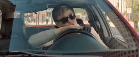 Ansel Elgort cantando dentro de una automóvil en Baby Driver 1
