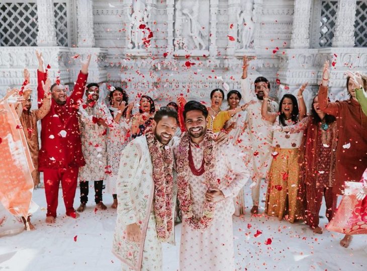 Familia celebrando una boda tradicional hindú con una pareja gay