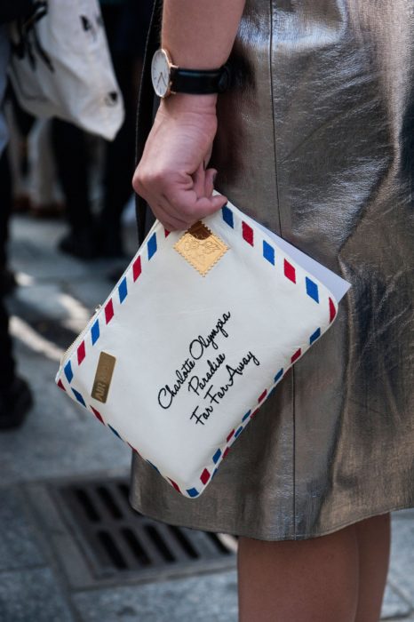 Chica sujetando una bolsa de mano en forma de carta 