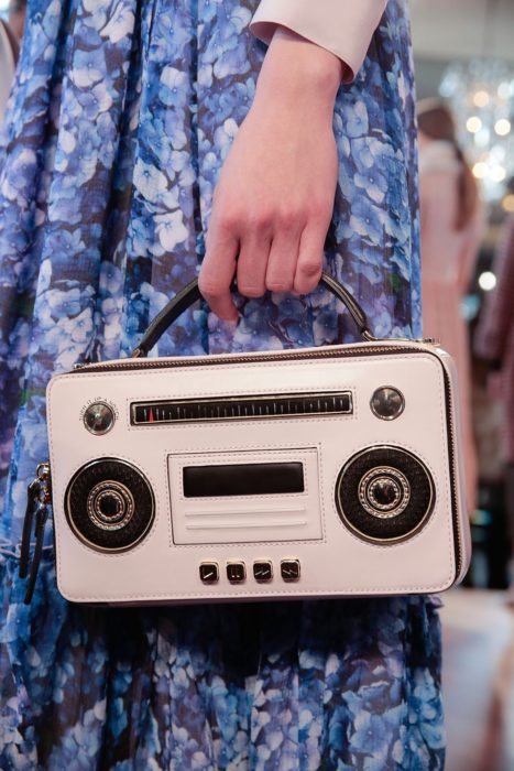Chica sujetando un bolso con forma de grabadora de música 