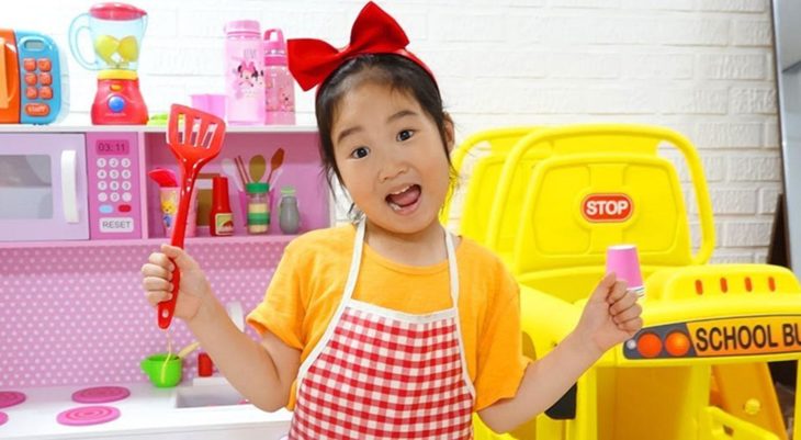 Boram sosteniendo una espátula de juguete junto a su cocina de fantasía