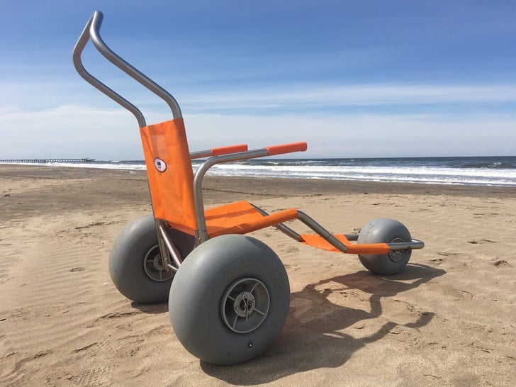 Silla de ruedas con llantas anchas de goma, especiales para personas que no pueden caminar y quieren disfrutar de la playa 
