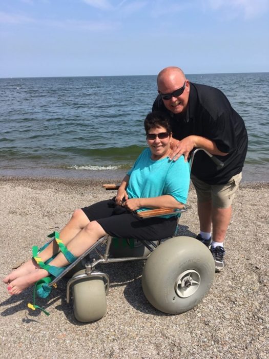 Persona que no puede caminar usando una silla especial para la playa 